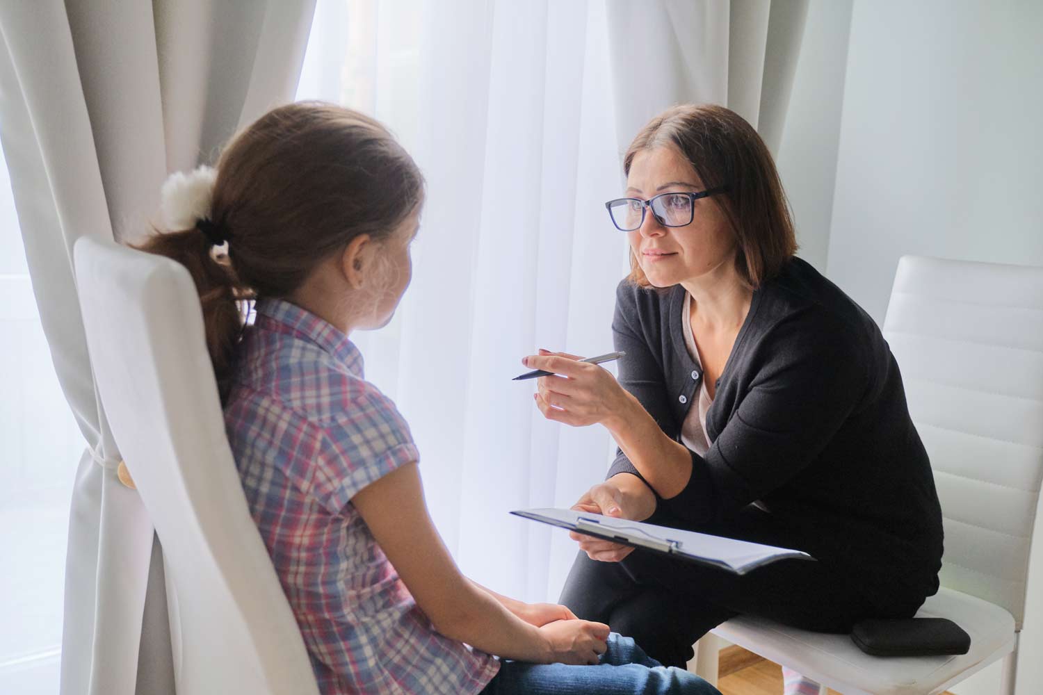 Child speaking with a behavioral therapist during a counseling session, focused on emotional regulation, behavior management, and mental health support.