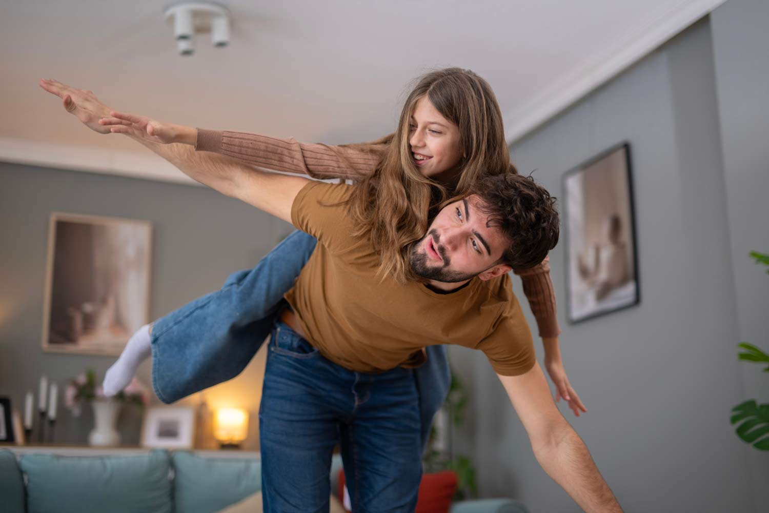 Father and daughter playing airplane together at home, illustrating positive parent-child interaction, family bonding, and Parent-Child Interaction Therapy (PCIT).