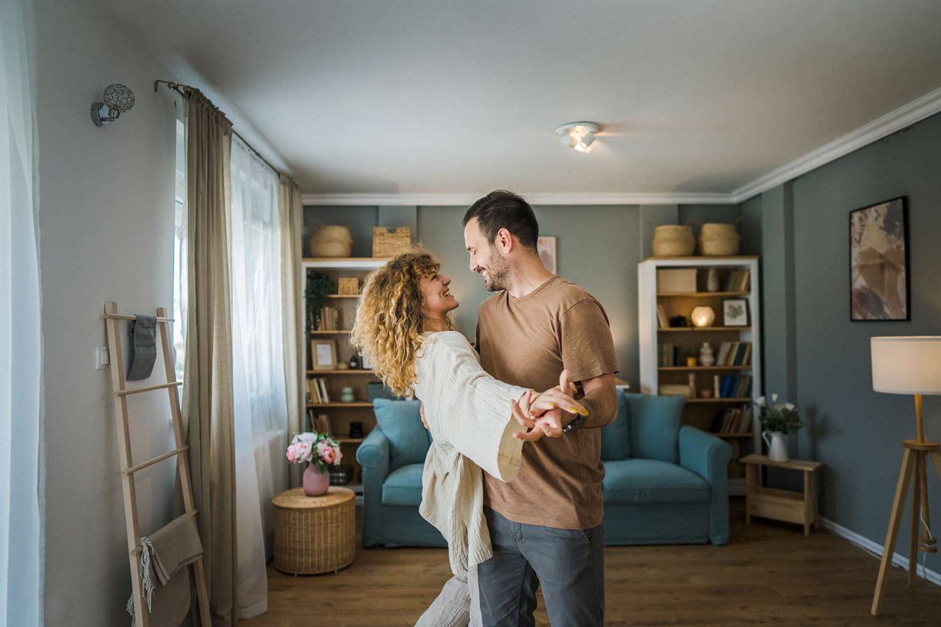 Happy couple dancing together at home after strengthening their relationship through healthy communication and emotional connection.