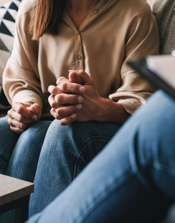 Couple holding hands during a counseling session with a licensed therapist, receiving relationship and mental health support.