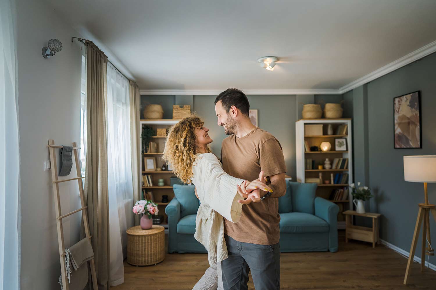 Happy couple dancing together at home after strengthening their relationship through healthy communication and emotional connection.